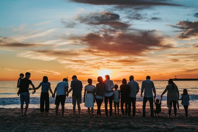 A family holding hands on a beach at sunset